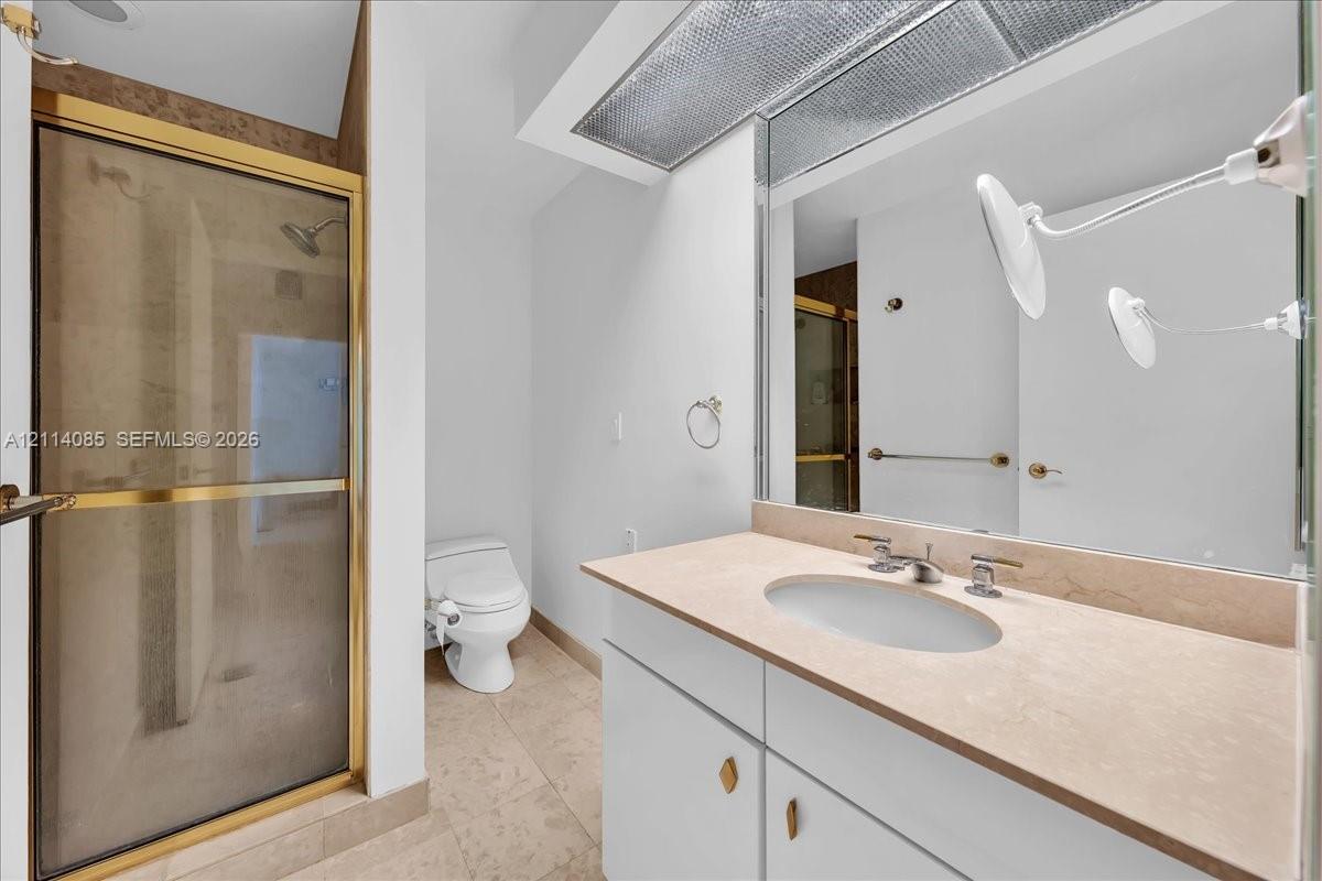 Bathroom featuring a vanity with stone-finish countertop, undermount sink, and integrated cabinetry