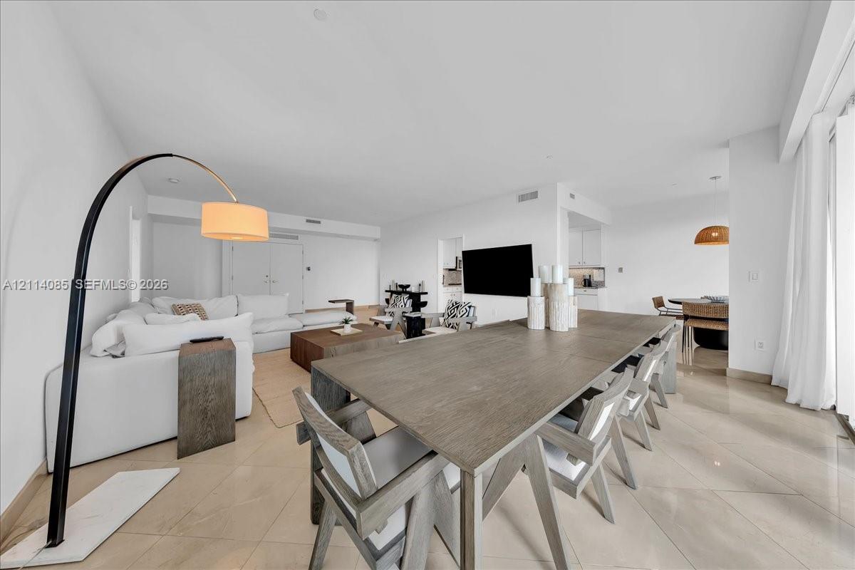 Open-concept interior featuring large-format tile flooring, recessed lighting, and crisp white wall finishes