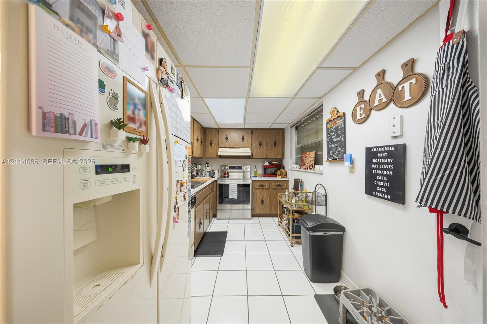 Kitchen featuring wood cabinetry, stainless steel appliances, and ceramic tile flooring