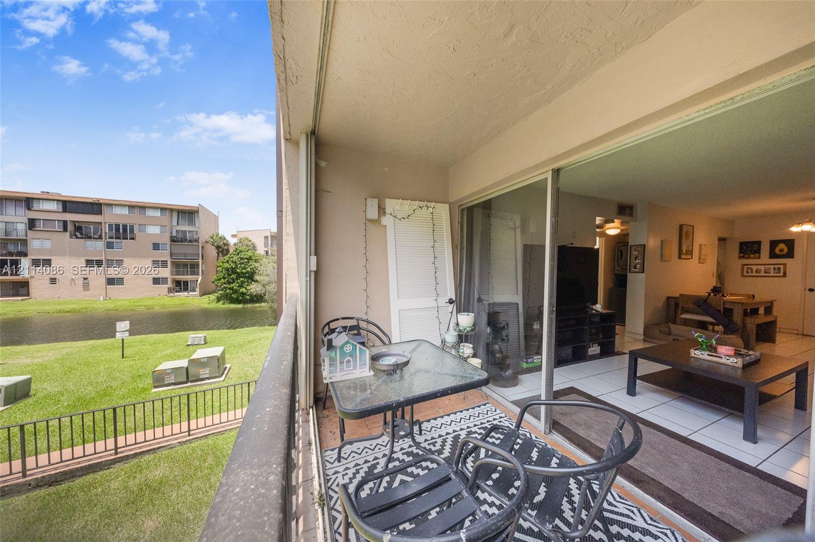 Covered balcony with metal railing, sliding glass doors, and water-facing exterior exposure