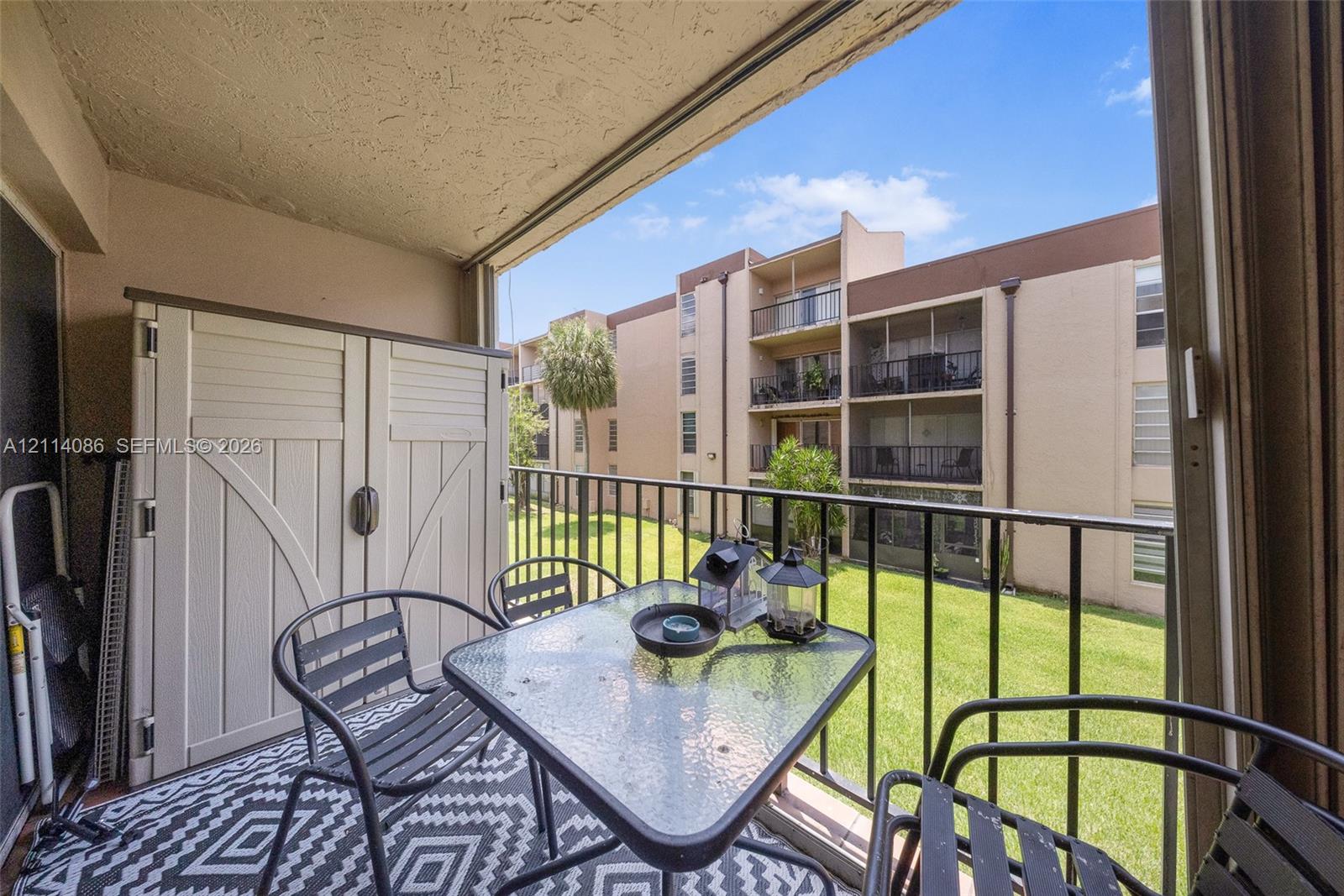 Covered balcony featuring a metal railing and built-in storage unit