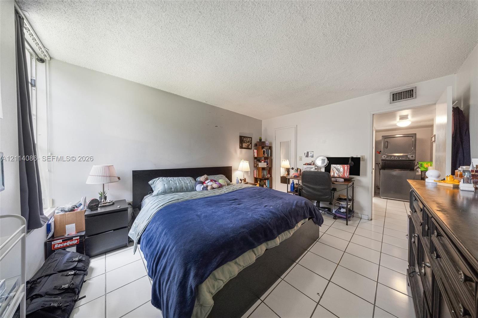 Interior space featuring ceramic tile flooring, neutral wall tones, and large vertical window