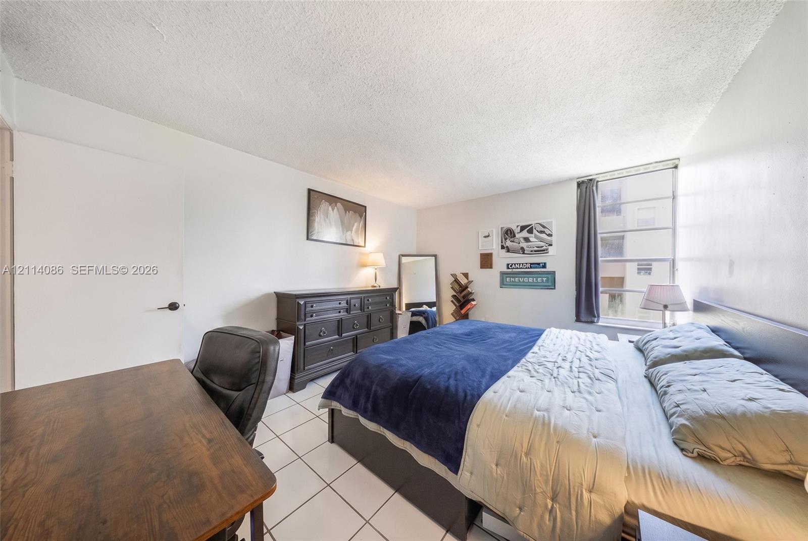 Room featuring ceramic tile flooring, neutral wall tones, and a multi-pane window
