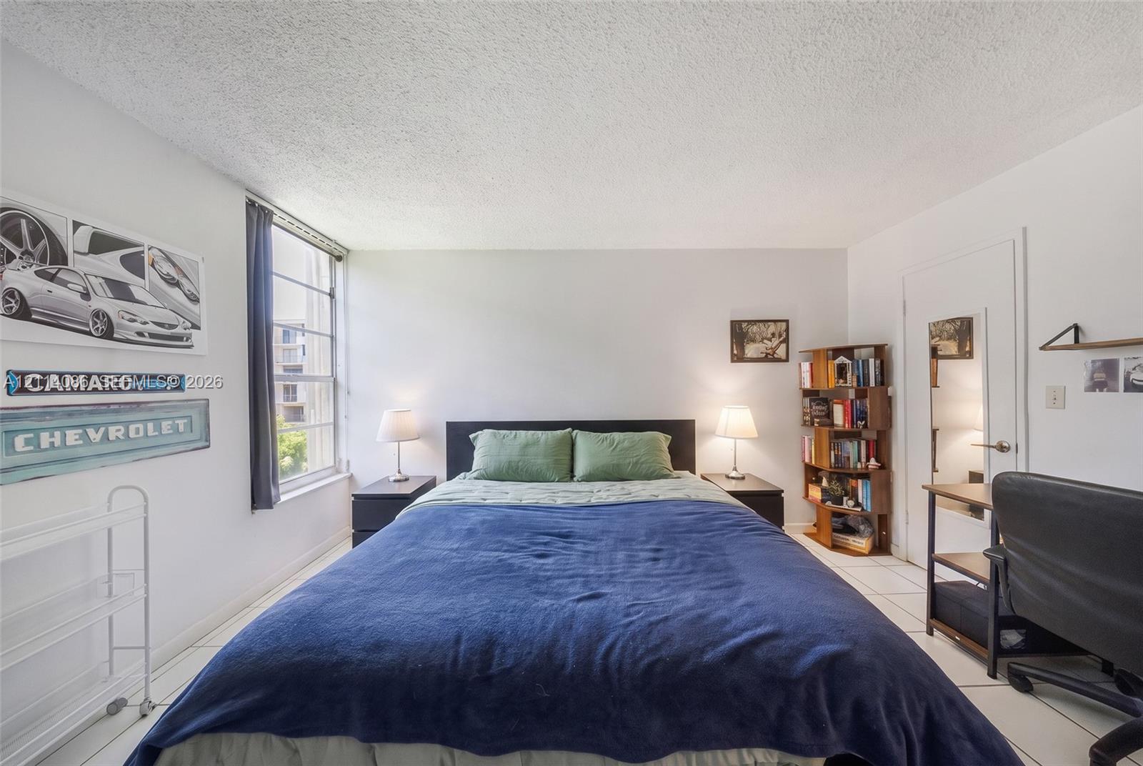 Room featuring light-toned tile flooring, neutral wall paint, and a large multi-pane window