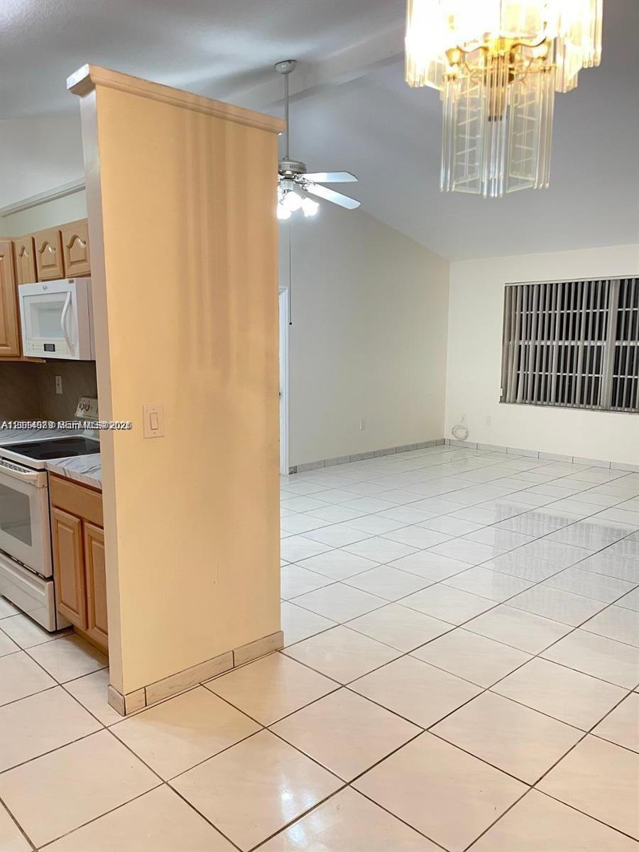 Vaulted ceilings, tile flooring, built-in cabinetry, ceiling fan, and multi-tiered glass chandelier Vaulted ceilings, tile flooring, built-in cabinetry, ceiling fan, and multi-tiered glass chandelier