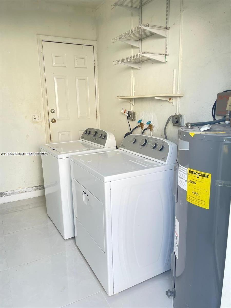 Utility area featuring large-format ceramic tile flooring, wall-mounted wire shelving, and a six-panel door