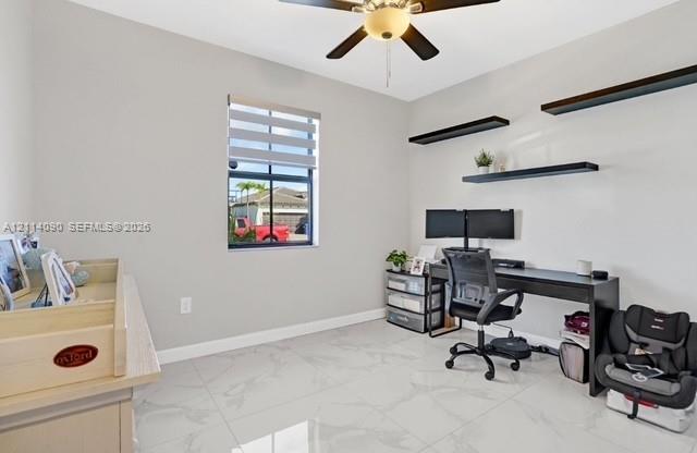 Room featuring large-format tile flooring, a central ceiling fan with an integrated light fixture, three mounted floating shelves, and a window equipped with horizontal zebra shades