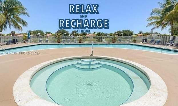 In-ground swimming pool and circular spa featuring concrete decking, metal perimeter fencing, and integrated stairs In-ground swimming pool and circular spa featuring concrete decking, metal perimeter fencing, and integrated stairs