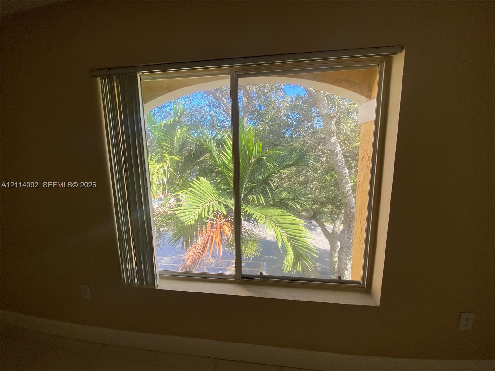 Single-hung window featuring an arched architectural frame and exterior greenery