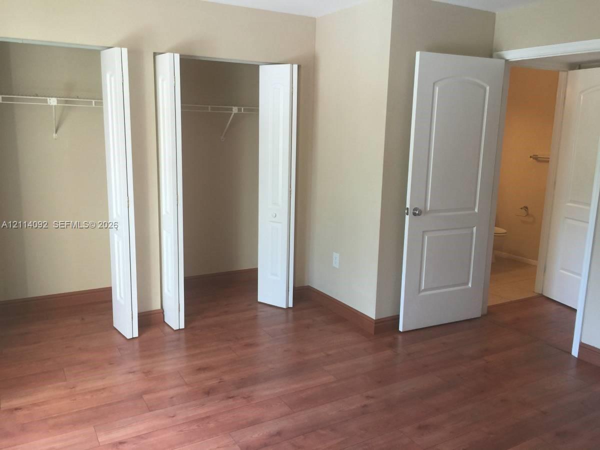 Wood-finish flooring, dual bi-fold door closets with integrated shelving, and two-panel interior doors