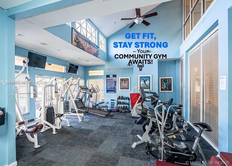 Fitness center featuring vaulted ceilings, oversized windows, and neutral carpeting