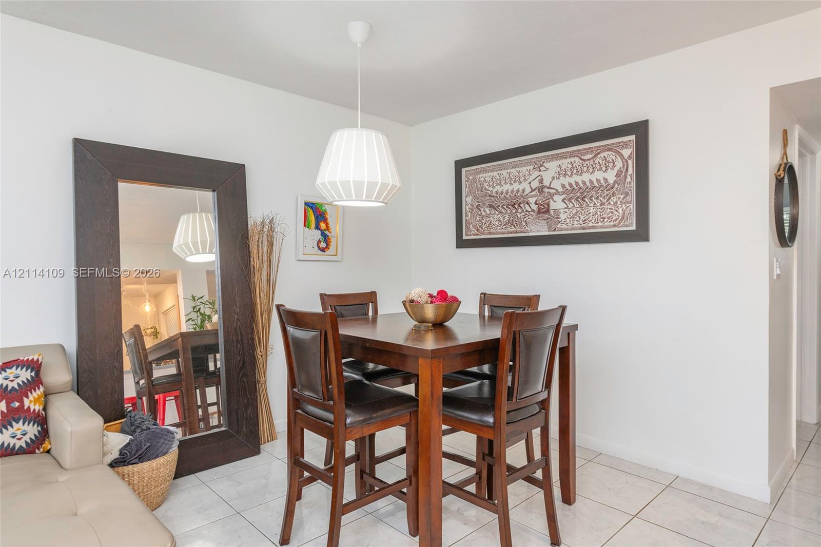 Neutral-toned tile flooring, white wall finishes, and a contemporary pendant light fixture