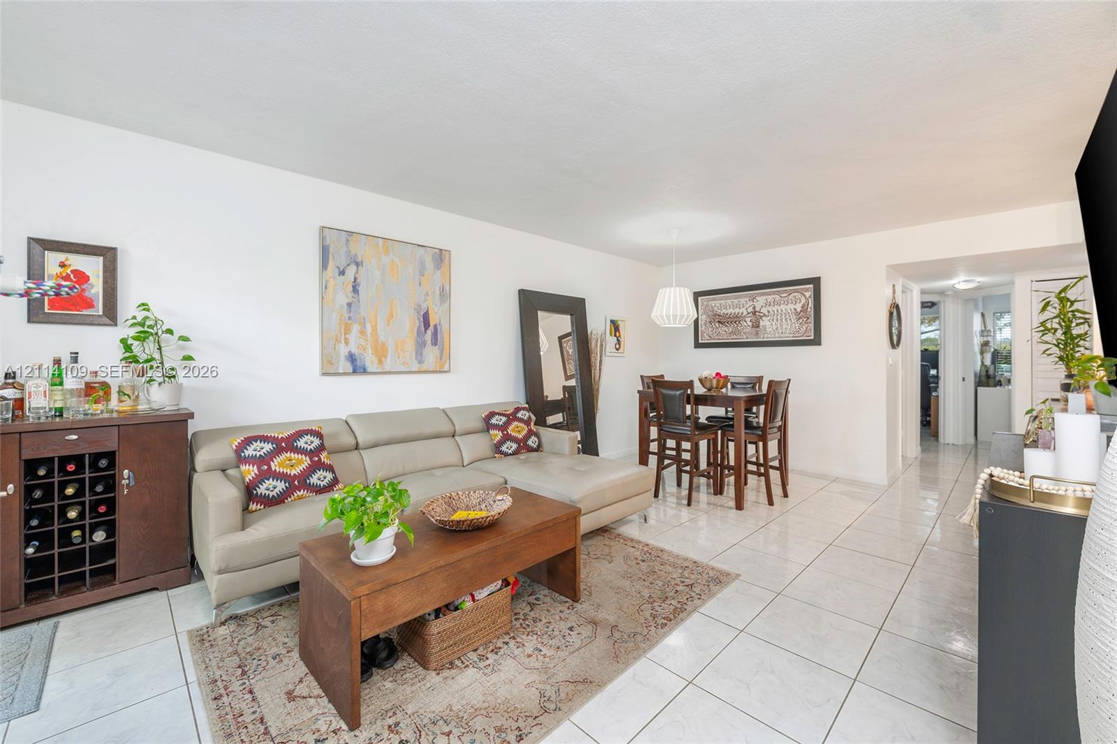Neutral-toned tile flooring, white wall finishes, and a contemporary drum-style pendant light fixture