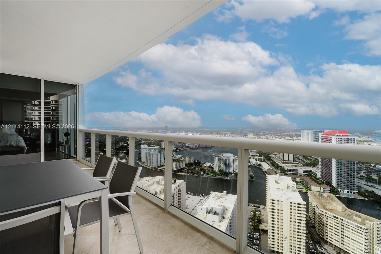 Private balcony featuring tile flooring and a structural glass-panel railing