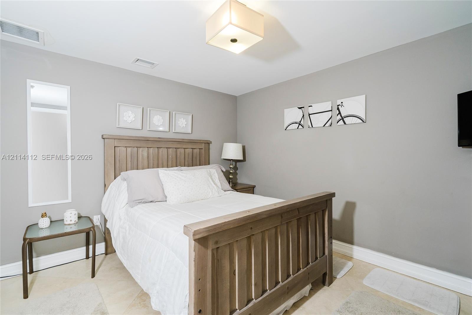 Neutral-toned walls paired with light-colored tile flooring and a square flush-mount ceiling fixture