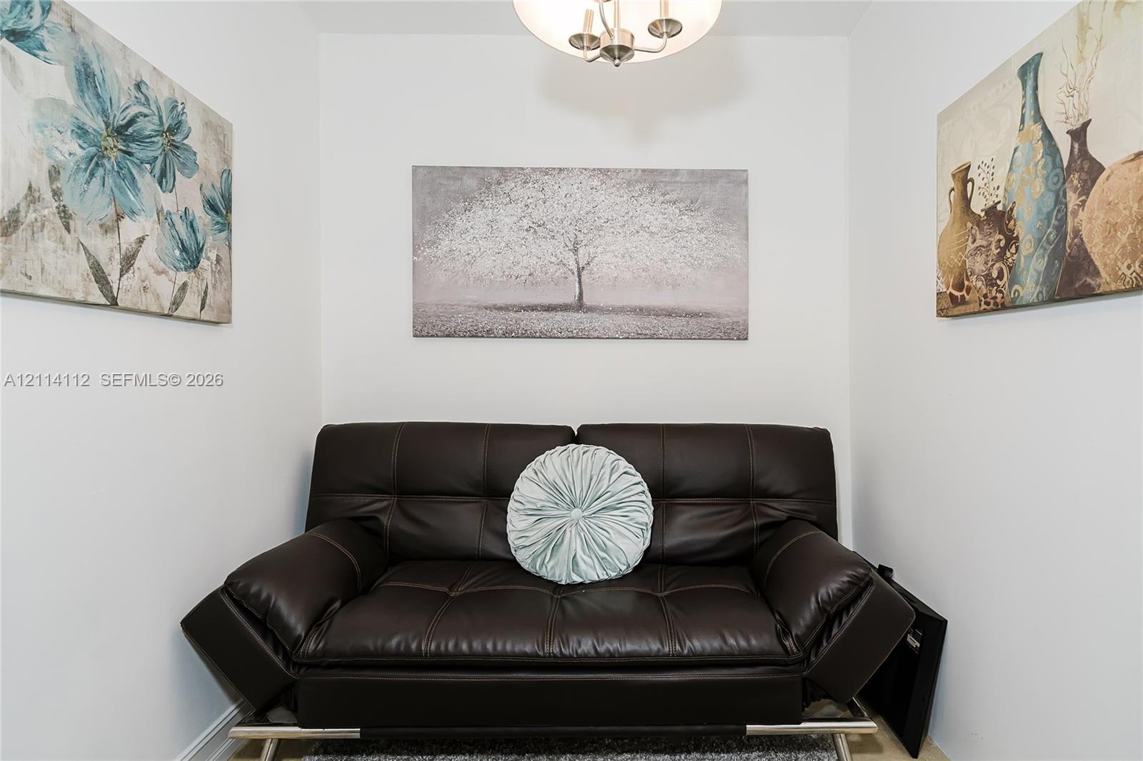 Neutral interior room featuring a three-arm overhead ceiling fixture with metallic finish