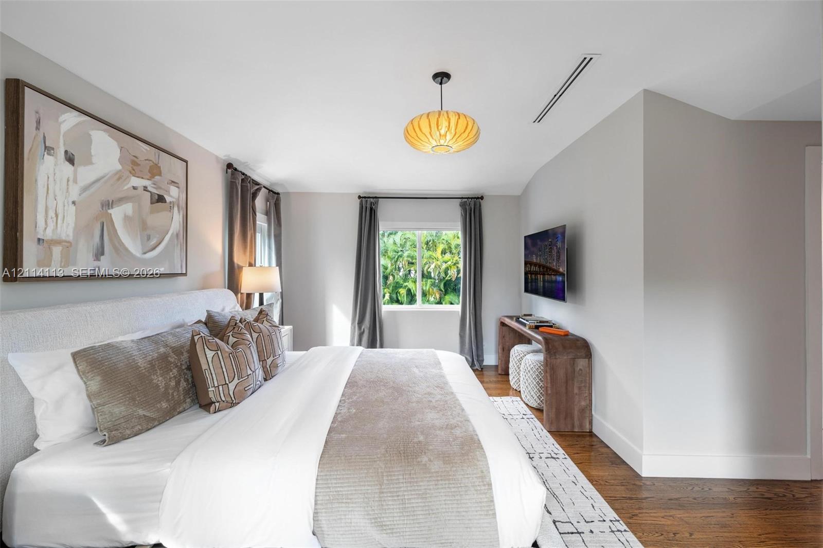 Bedroom featuring dark wood-finish flooring, a contemporary pendant light fixture, and recessed ceiling lighting