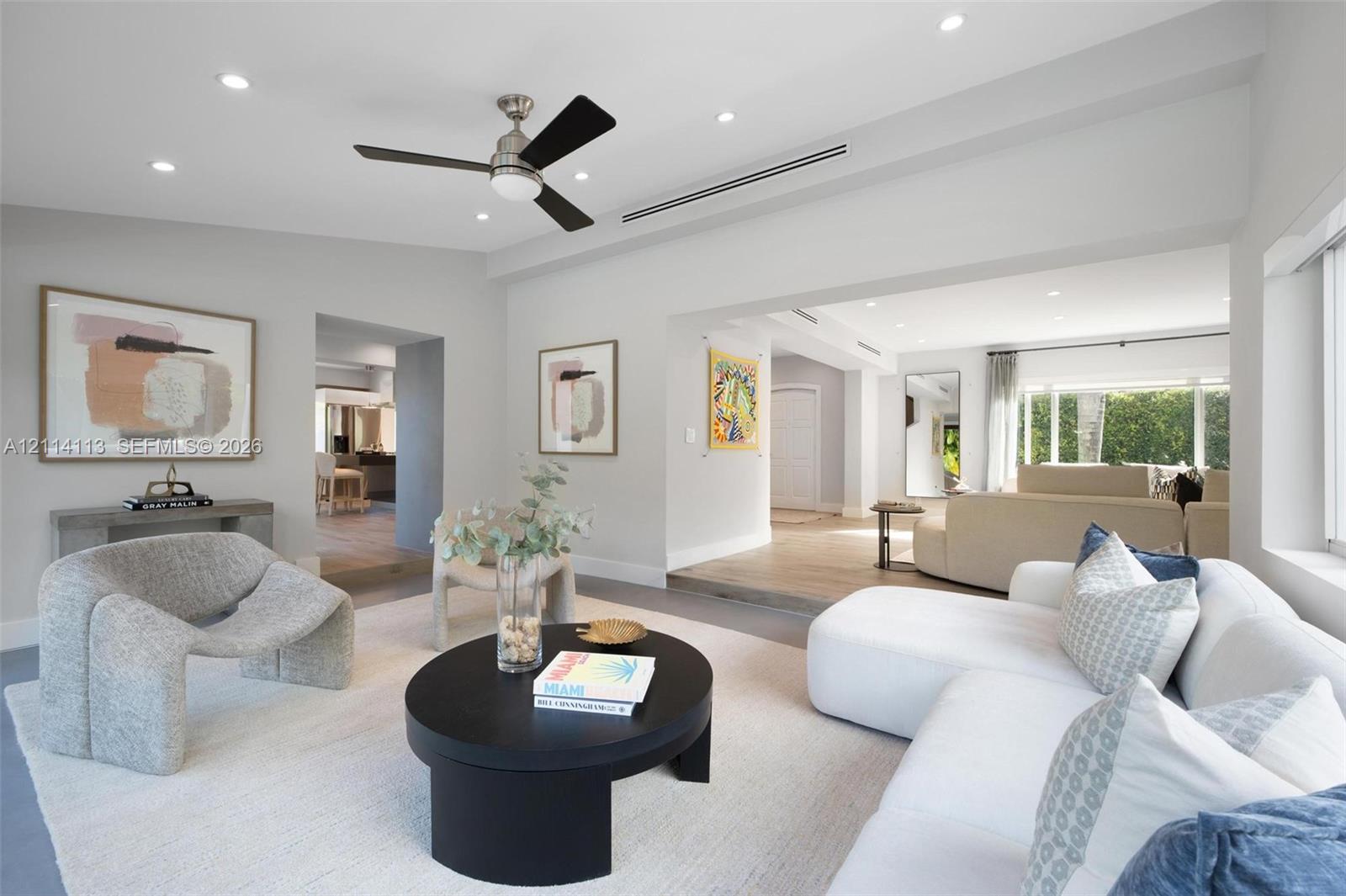 Neutral-toned interior featuring recessed lighting, a brushed-nickel ceiling fan, wood-finish flooring, and recessed linear HVAC diffusers