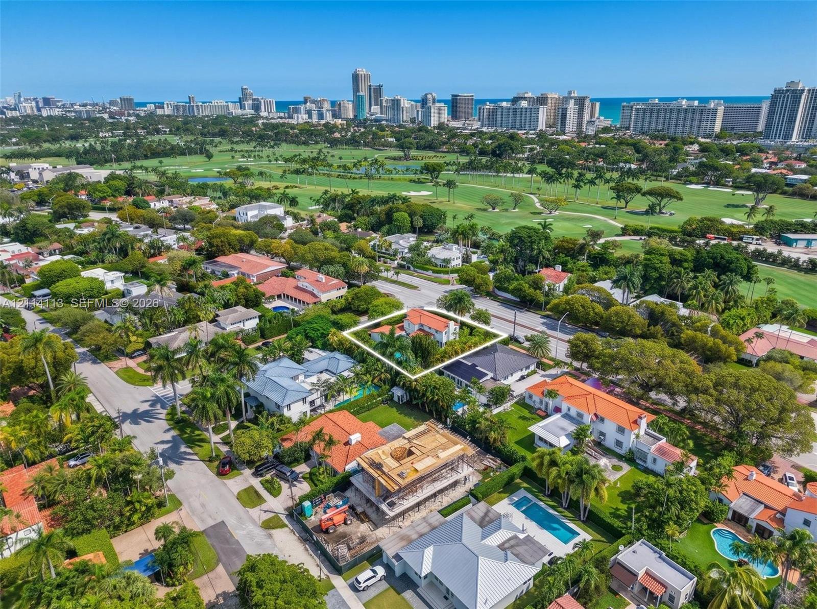 Aerial perspective of the residence next to prestigious La Gorce golf club, mature landscaping situated within a coastal urban environment