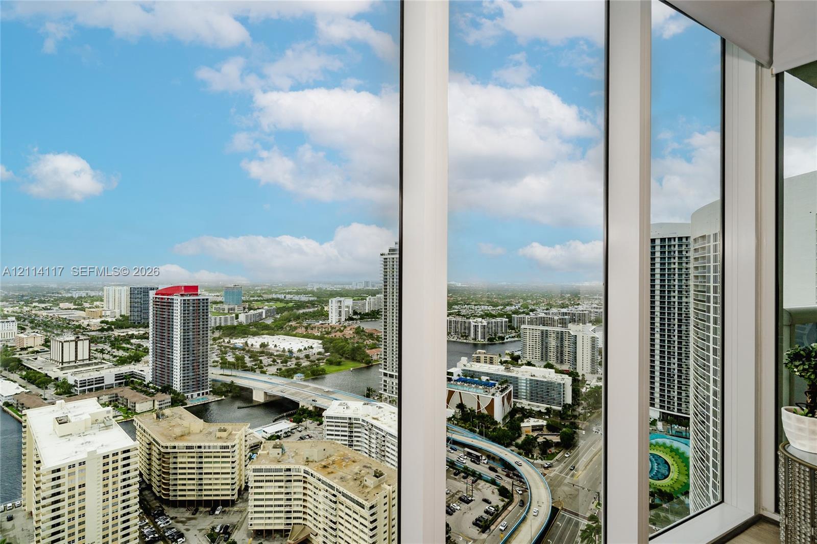 Floor-to-ceiling windows with expansive urban and waterway scenery
