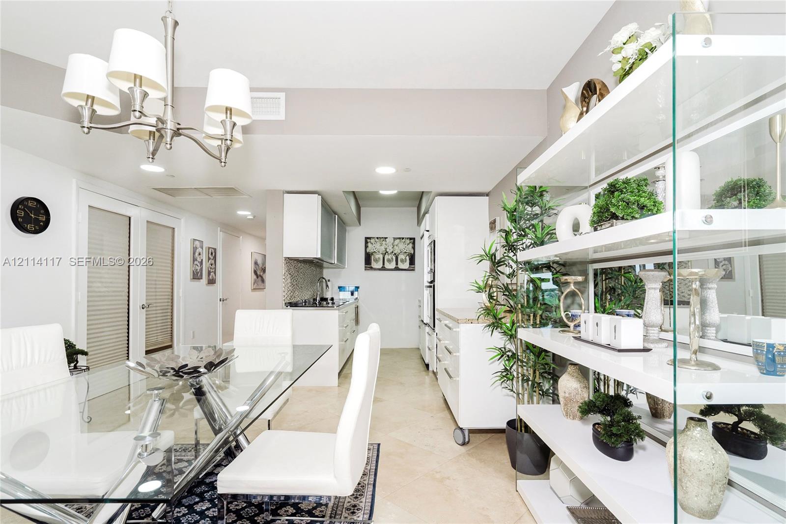 Open-concept space featuring large-format tile flooring, a multi-arm chandelier, built-in white cabinetry, and recessed lighting
