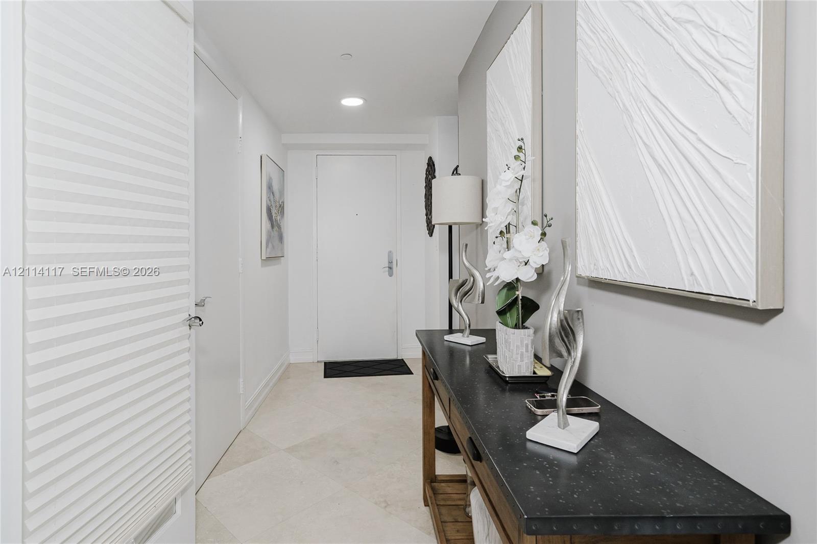 Entryway featuring neutral-toned stone-finish tile flooring, recessed ceiling lighting, and solid-core interior doors