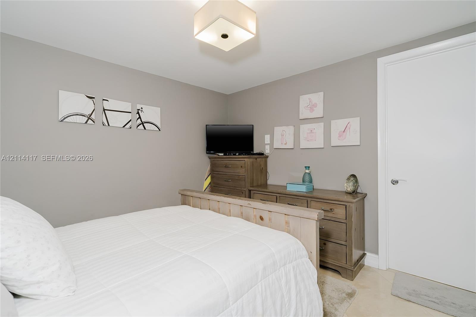 Neutral-toned interior space featuring a flush-mount geometric light fixture and smooth wall finishes