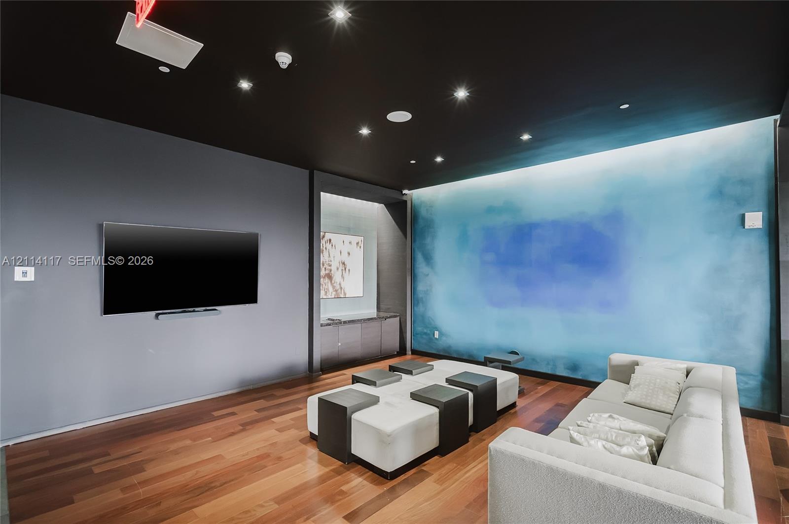 Wood-finish flooring, recessed ceiling lighting, built-in cabinetry, and integrated wall-mounted technology