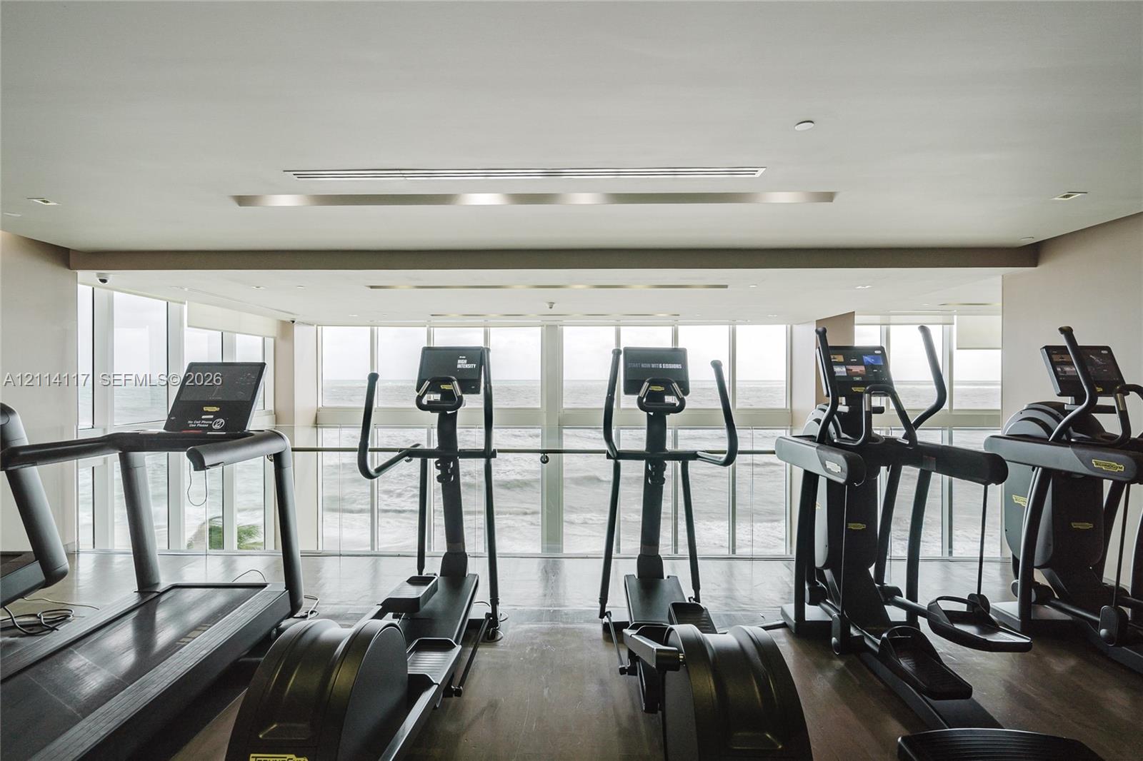 Fitness room featuring floor-to-ceiling windows and wood-finish flooring
