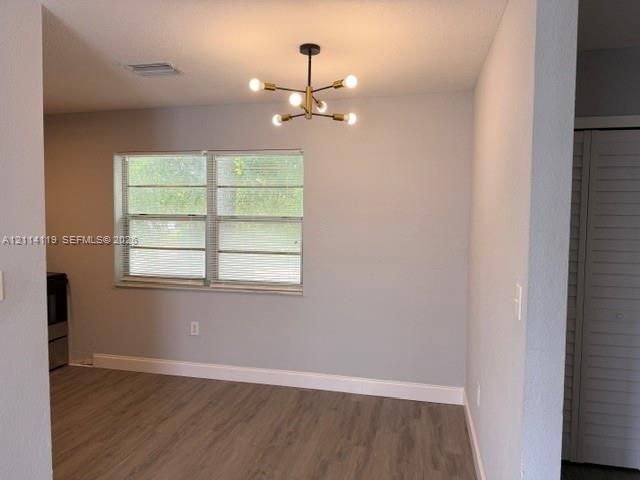 Modern six-light sputnik chandelier with a brass finish, wood-finish flooring, and white louvered closet doors