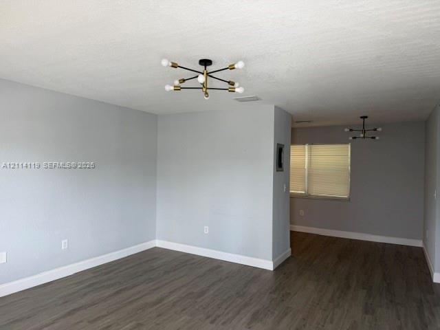 Neutral gray wall finish, wood-finish flooring, and modern multi-arm light fixtures with gold-tone accents