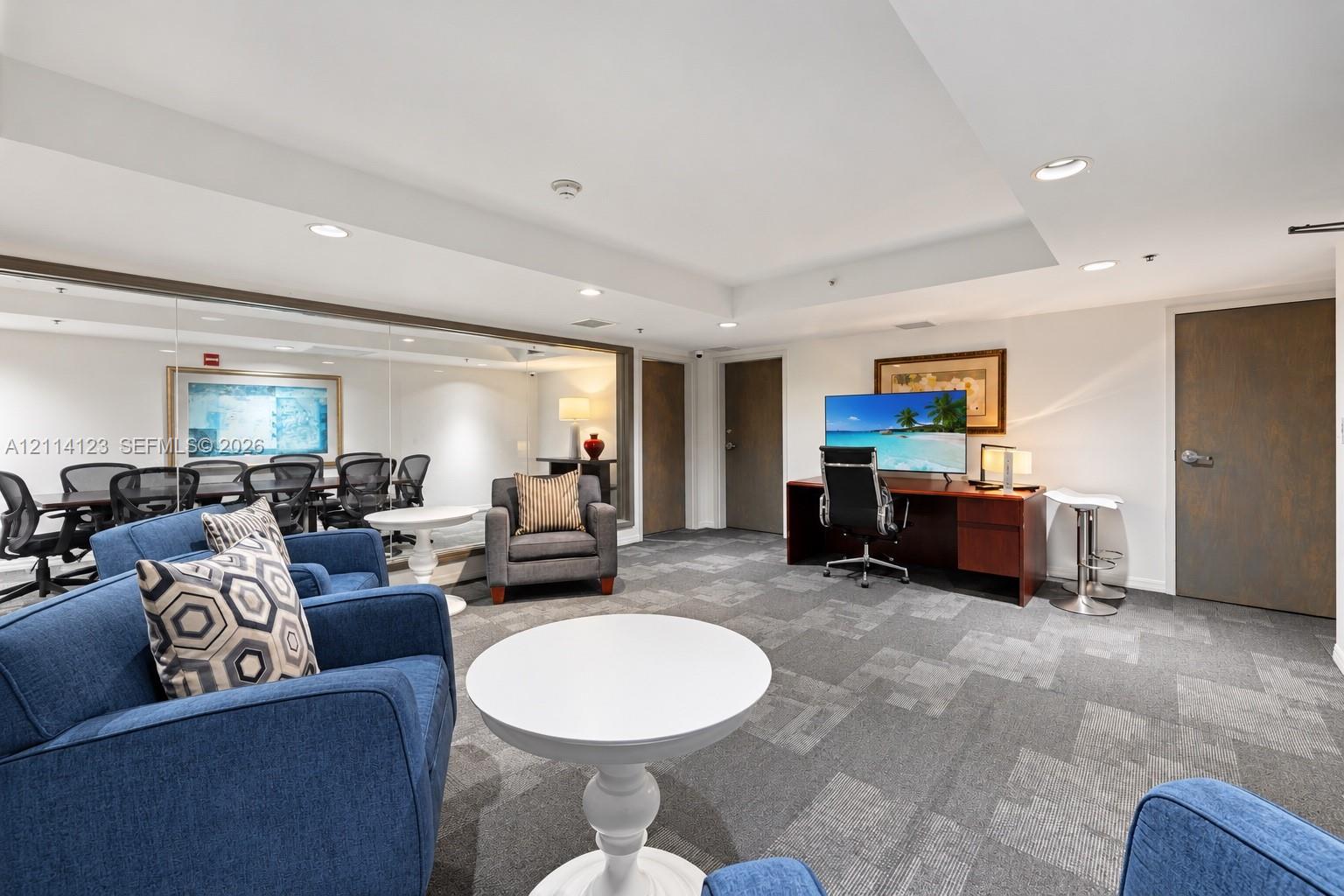 Open-concept room featuring wall-to-wall mirrors, recessed lighting, and patterned carpet flooring