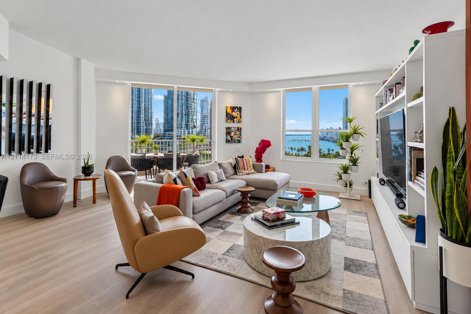 Living area featuring floor-to-ceiling windows, wood-finish flooring, built-in shelving, and a balcony