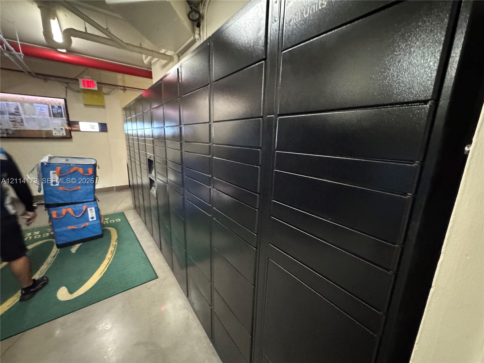 Secure metal parcel storage lockers featuring a matte black finish and integrated electronic kiosk interface