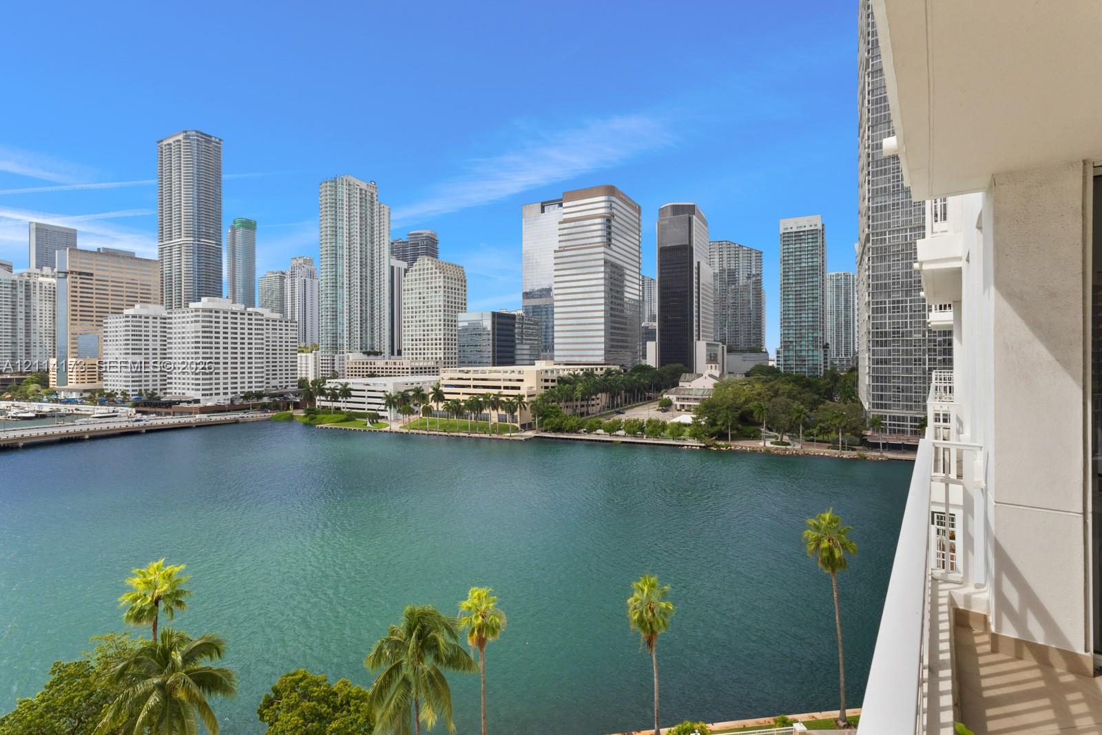 Private balcony featuring a metal railing and panoramic scenery of the waterfront and urban skyline