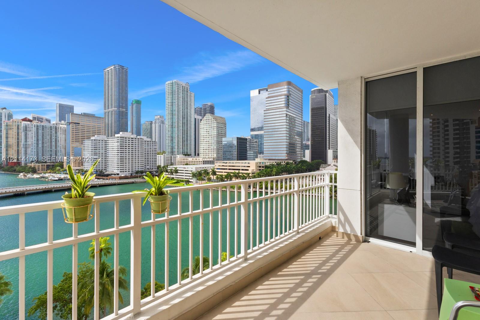 Private balcony featuring ceramic tile flooring, a white metal railing, and floor-to-ceiling glass sliding doors