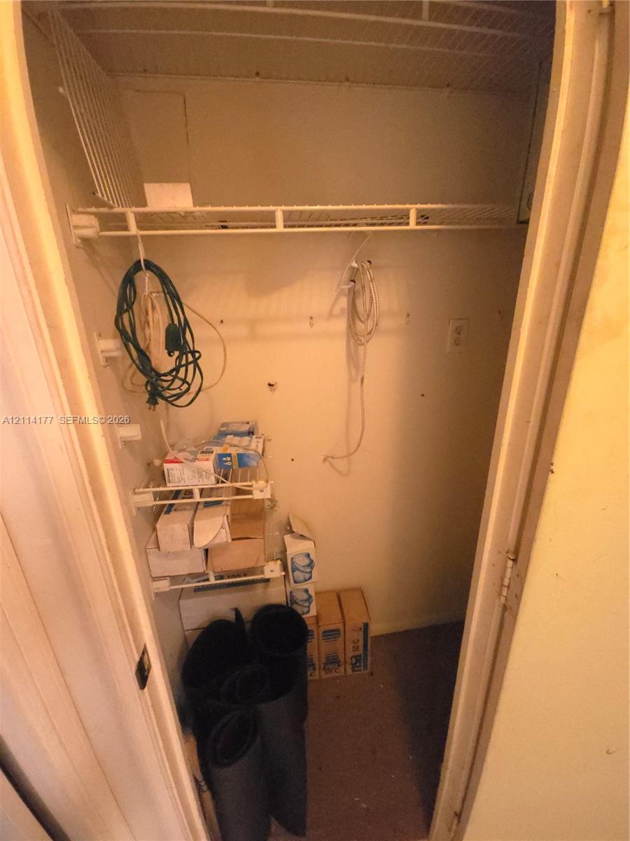 Storage closet featuring wire shelving and a hanging rod