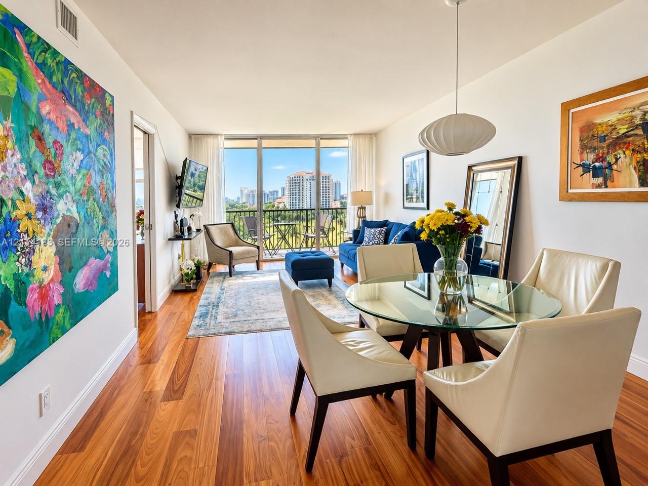 Open-concept interior featuring wood-finish flooring, floor-to-ceiling windows, and a private balcony