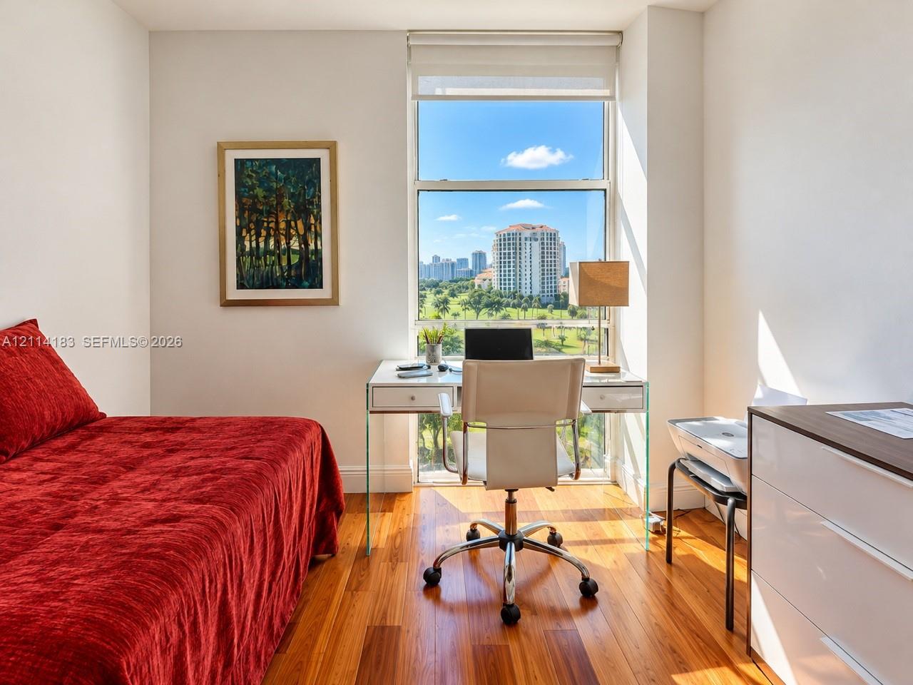 Wood-finish flooring and a tall, multi-pane window featuring an urban and landscape panorama