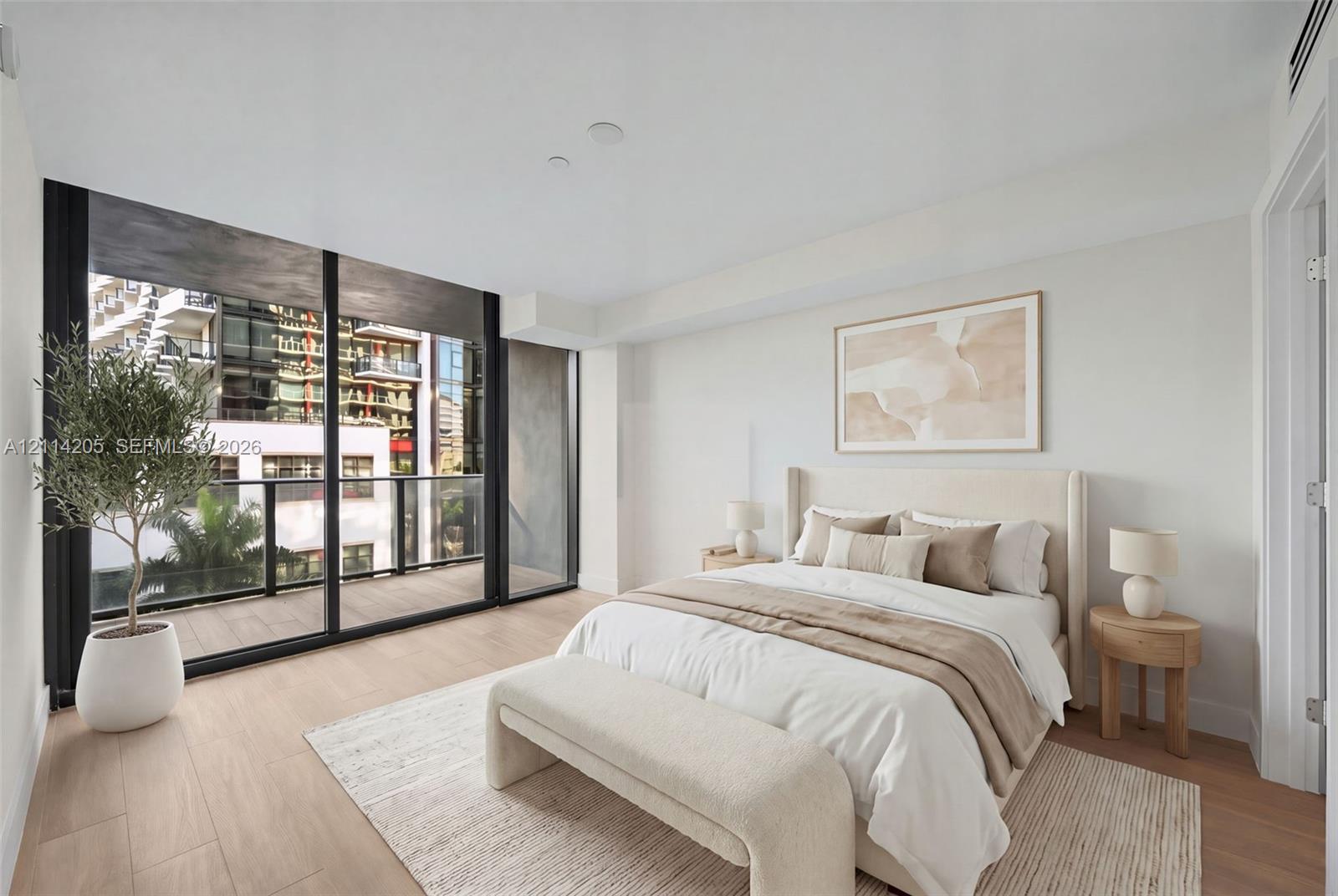 Floor-to-ceiling glass sliding doors, wood-finish flooring, and a private balcony with black metal railings - staged Floor-to-ceiling glass sliding doors, wood-finish flooring, and a private balcony with black metal railings - staged