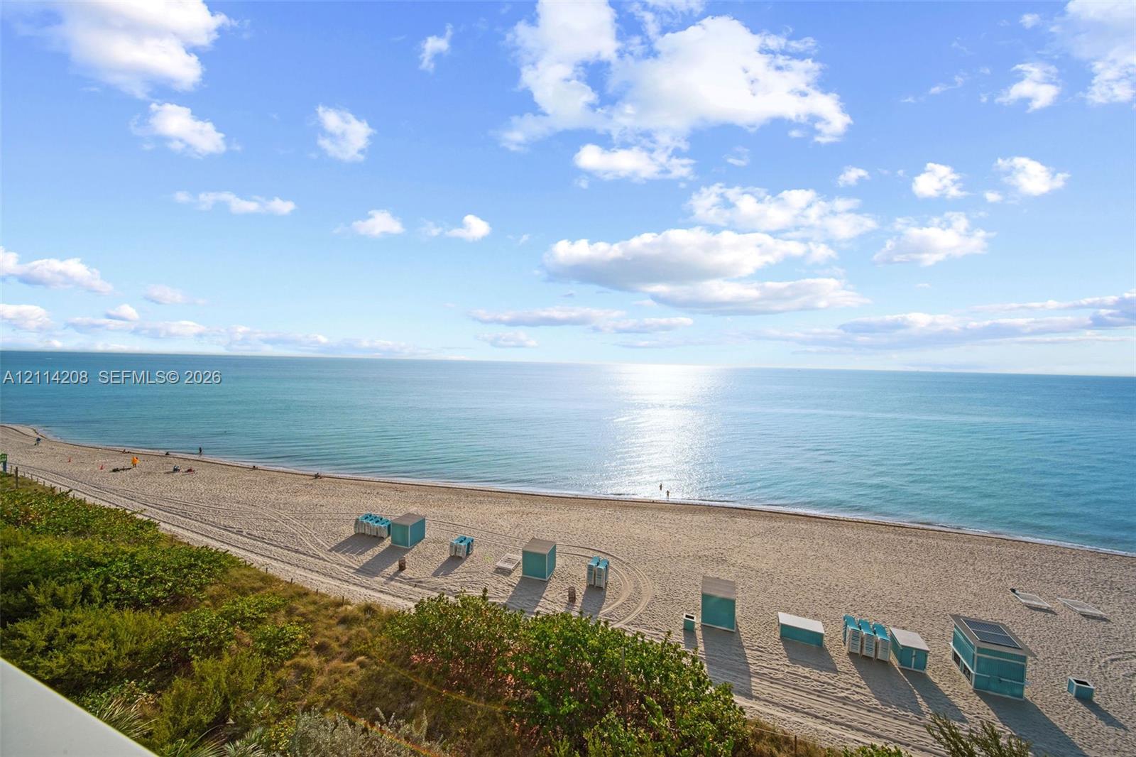 Oceanfront scenery featuring a sandy beach, turquoise water, and expansive horizon line