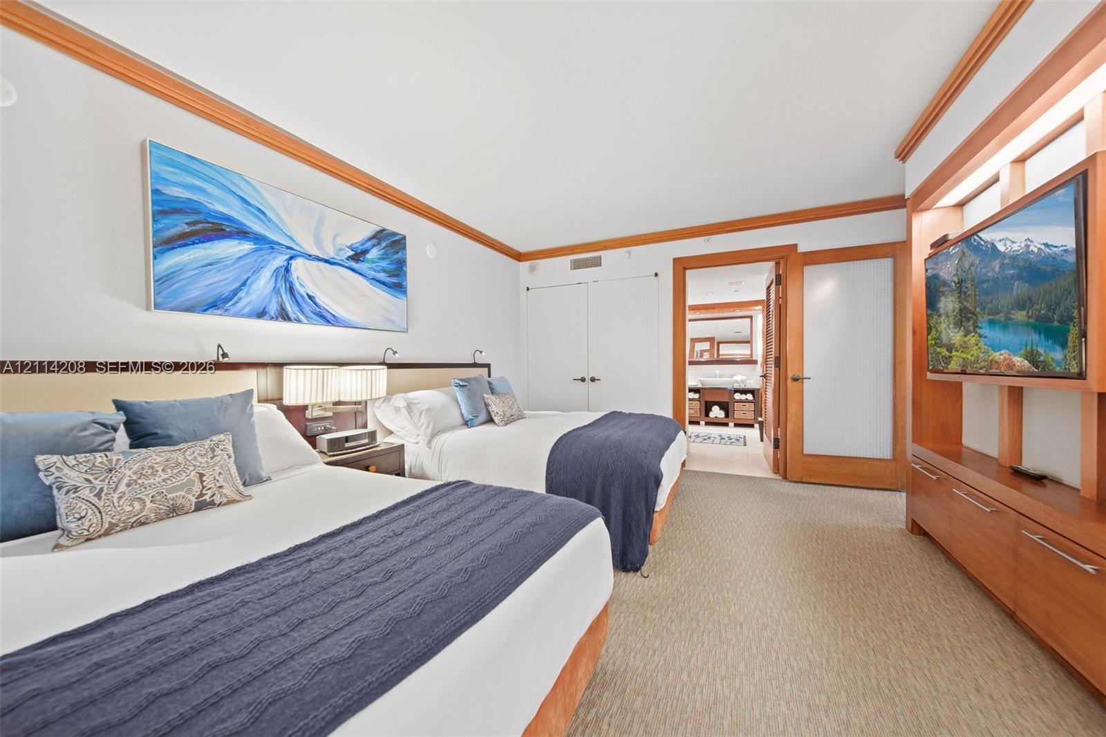 Custom wood trim detailing, built-in wooden media cabinetry, recessed lighting, and a frosted glass-panel door
