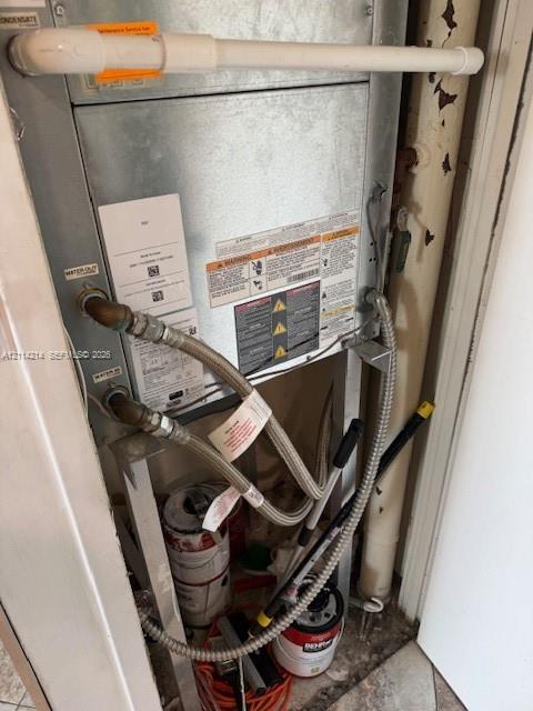 Metal HVAC air handler unit featuring a metallic casing, reinforced braided water supply lines, and external condensate drainage piping