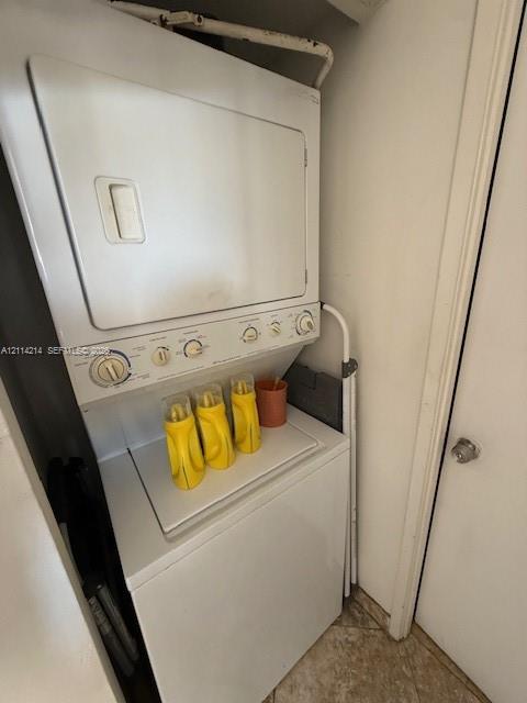 Stacked white washer and dryer unit with top-loading machine and manual control knobs