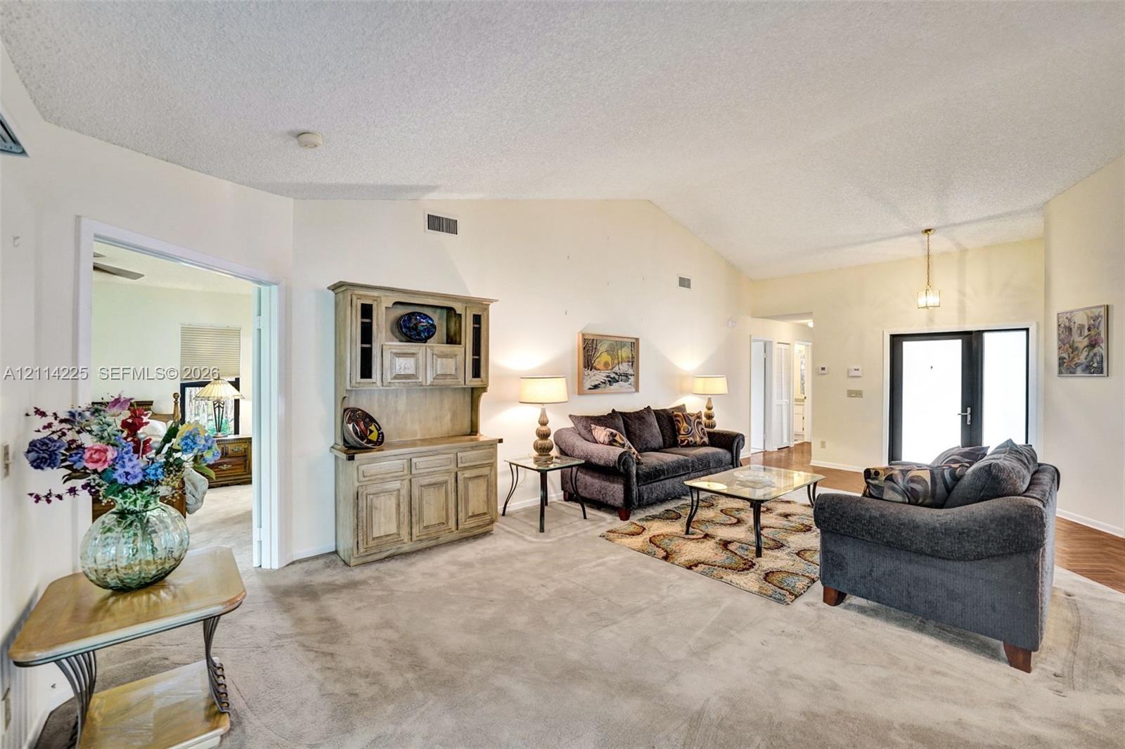Vaulted ceilings, built-in wooden cabinetry, and glass-paned exterior door