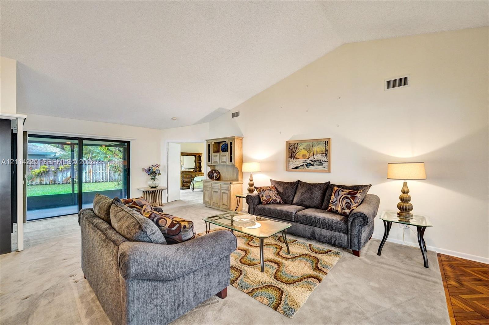 Vaulted ceilings, sliding glass doors to the exterior, and built-in wood cabinetry