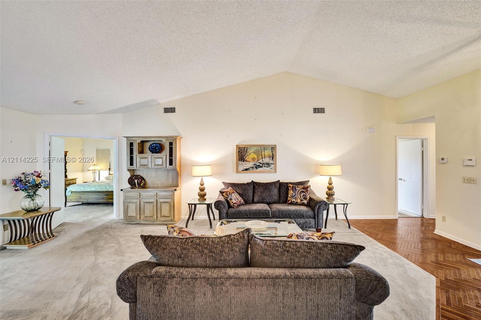 Vaulted ceilings, built-in wooden cabinetry, and herringbone-patterned wood-finish flooring
