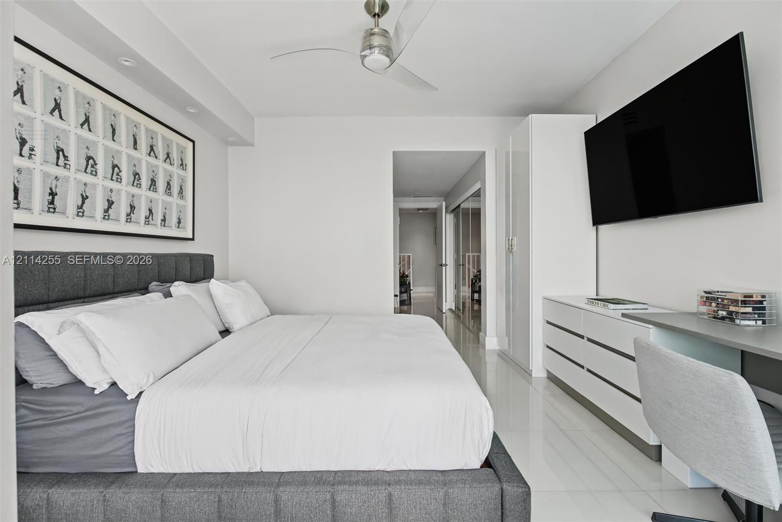 Neutral-toned interior featuring polished tile flooring, recessed ceiling lighting, a contemporary brushed-metal ceiling fan, and built-in white cabinetry