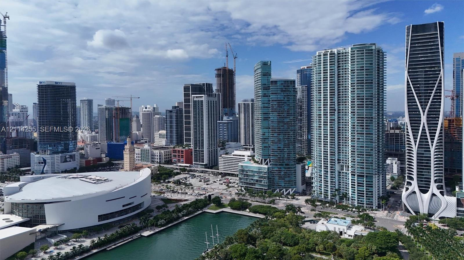 Aerial perspective of urban skyline featuring high-rise architecture, proximity to waterfront, and surrounding metropolitan landscape