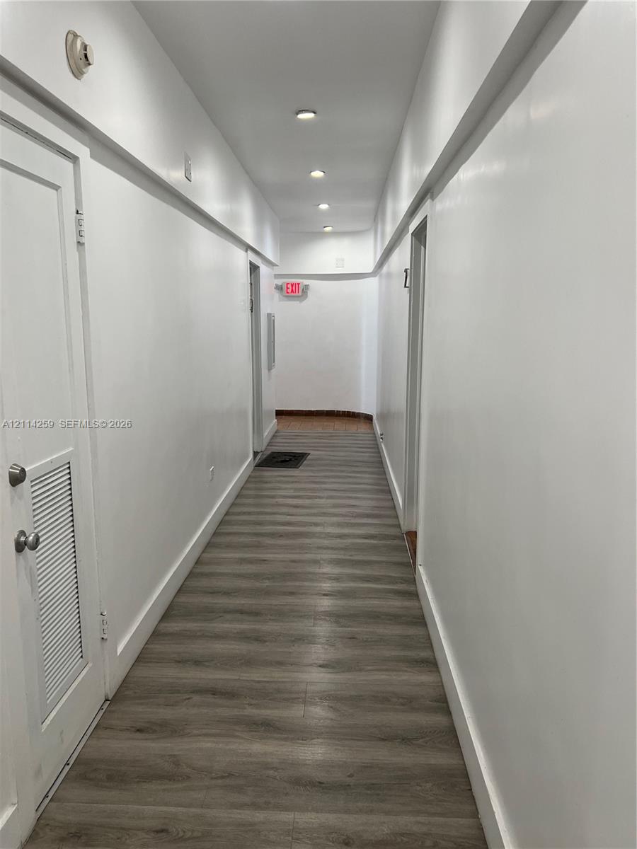 Hallway featuring wood-finish flooring, recessed lighting, and smooth-finish walls